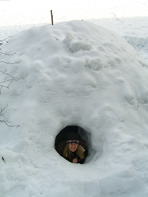 student peeking out of a complete quinzee