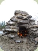 survival oven built from river rocks and clay